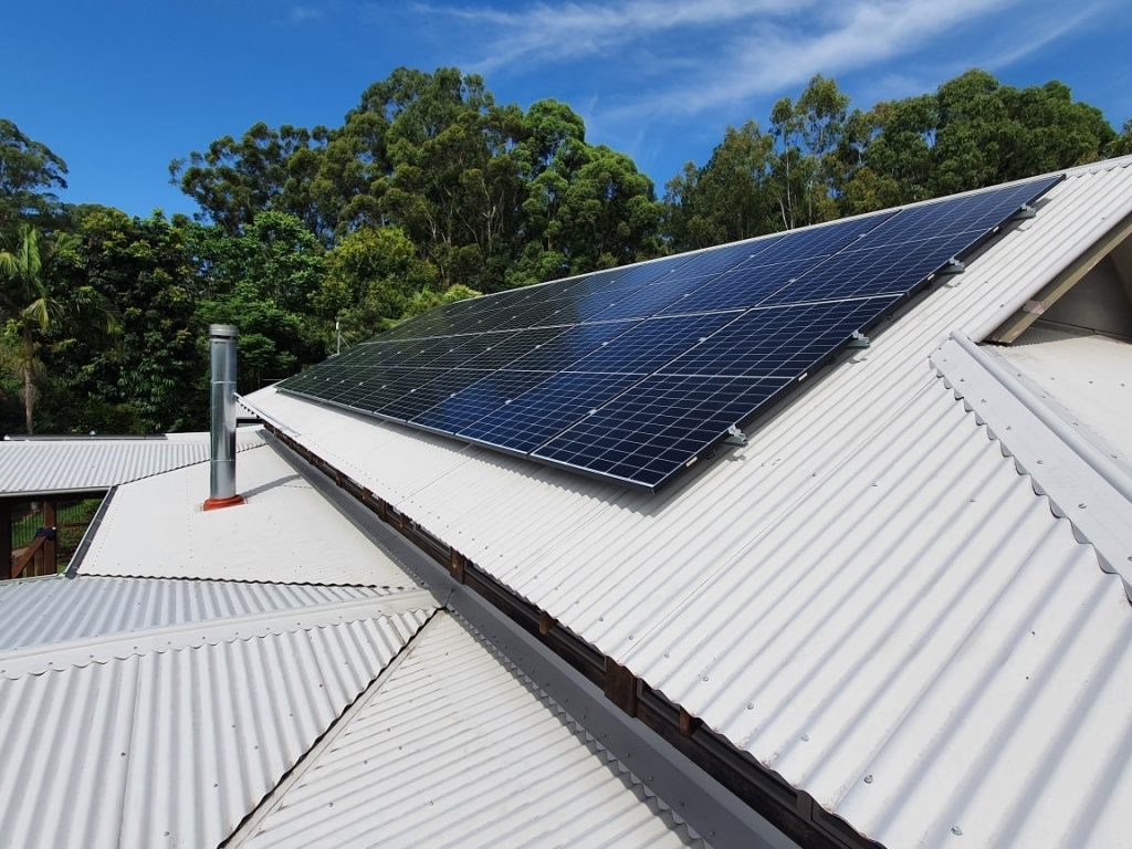 Solar panels on a corrugated iron roof surrounded by trees, residential solar by Sun Connect Solar in the Northern Rivers NSW