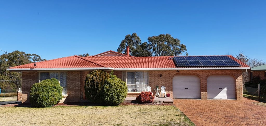 Brick home with solar panels installed by Sun Connect Solar on a red tiled roof