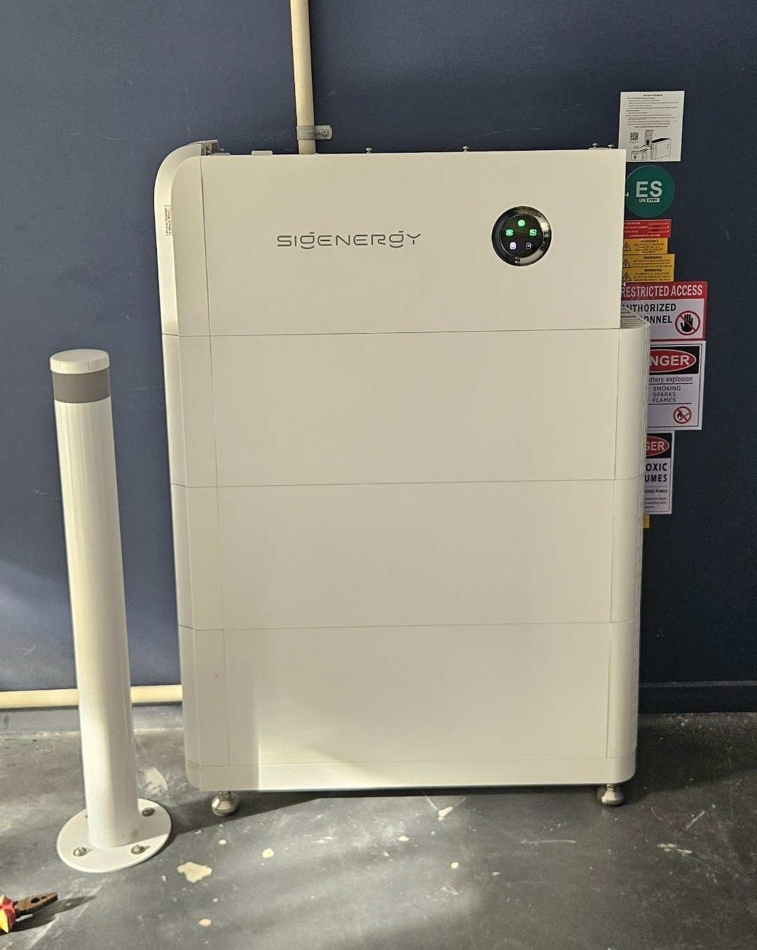 Sigenergy SigenStor 24 kWh battery with a protective bollard against a dark wall at a Bangalow home, installed by Sun Connect Solar