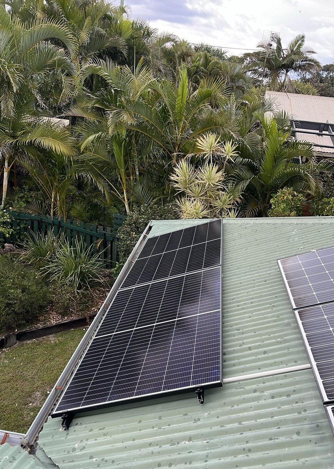 Jinko solar panels on a green corrugated roof among palms in Bogangar near Cabarita Beach Jinko solar panels on a green corrugated roof among palms in Bogangar near Cabarita Beach, installed by Sun Connect Solar