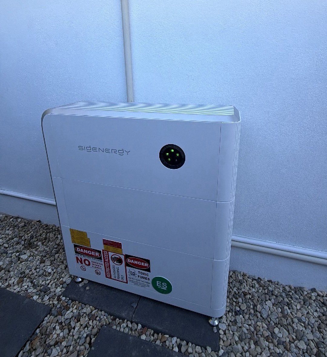 Sigenergy SigenStor 16 kWh battery on pavers against a white outside wall at a Byron Bay home Sigenergy SigenStor 16 kWh battery on pavers against a white outside wall at a Byron Bay home, installed by Sun Connect Solar