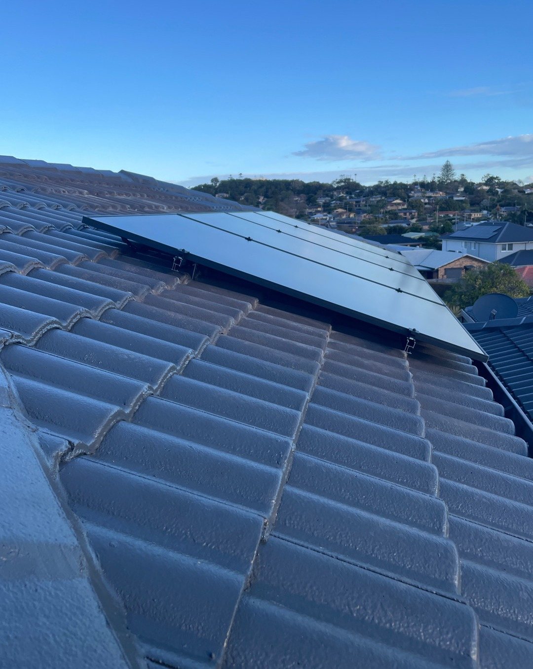 AIKO solar panels on a grey tile roof looking out over East Ballina rooftops AIKO solar panels on a grey tile roof looking out over East Ballina rooftops, installed by Sun Connect Solar
