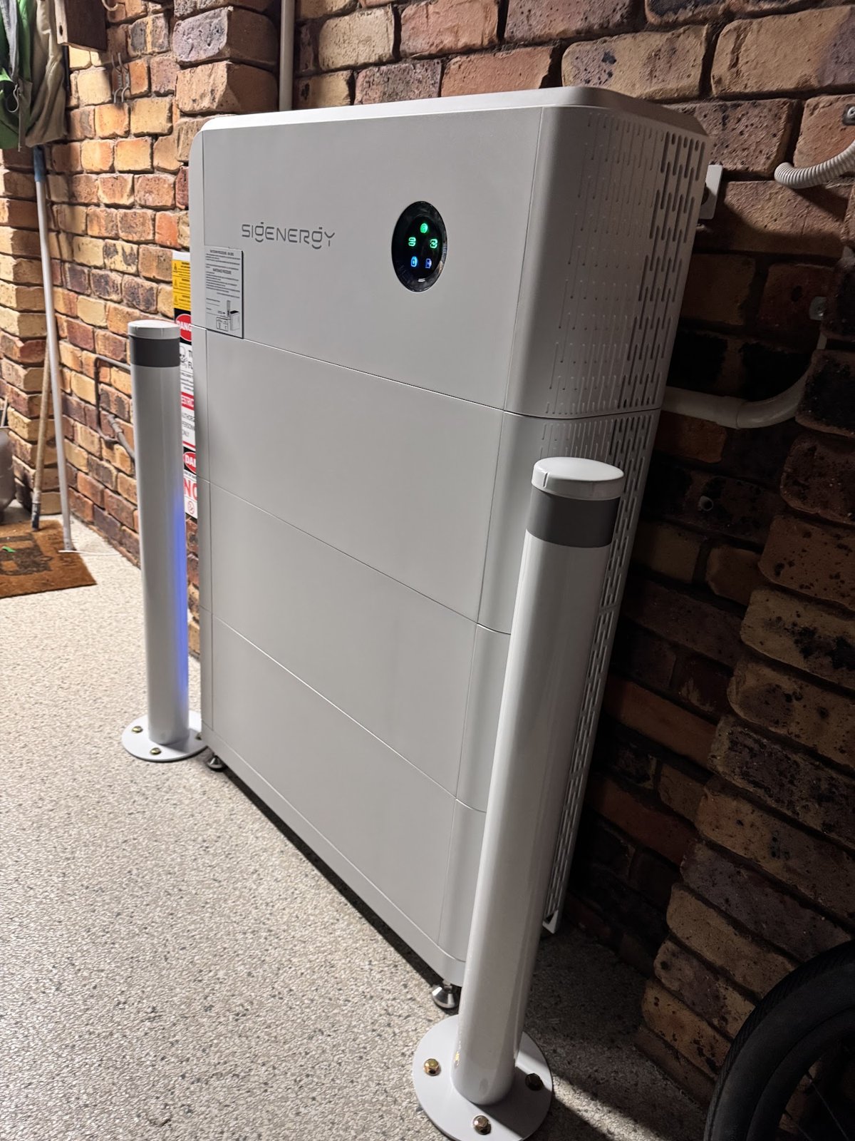 Sigenergy SigenStor 27 kWh battery with protective bollards against a brick wall in an East Ballina home, installed by Sun Connect Solar with Jinko solar