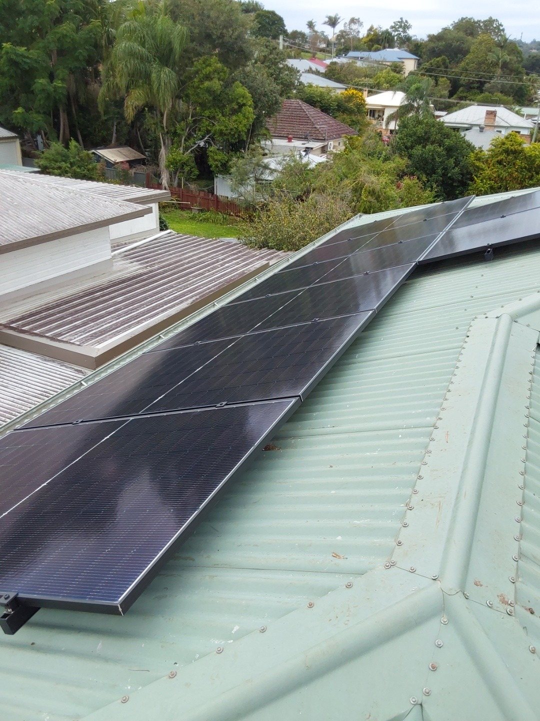 All-black Jinko Tiger Neo solar panels along a green Colorbond roof in East Lismore, part of a 10.12 kW install by Sun Connect Solar