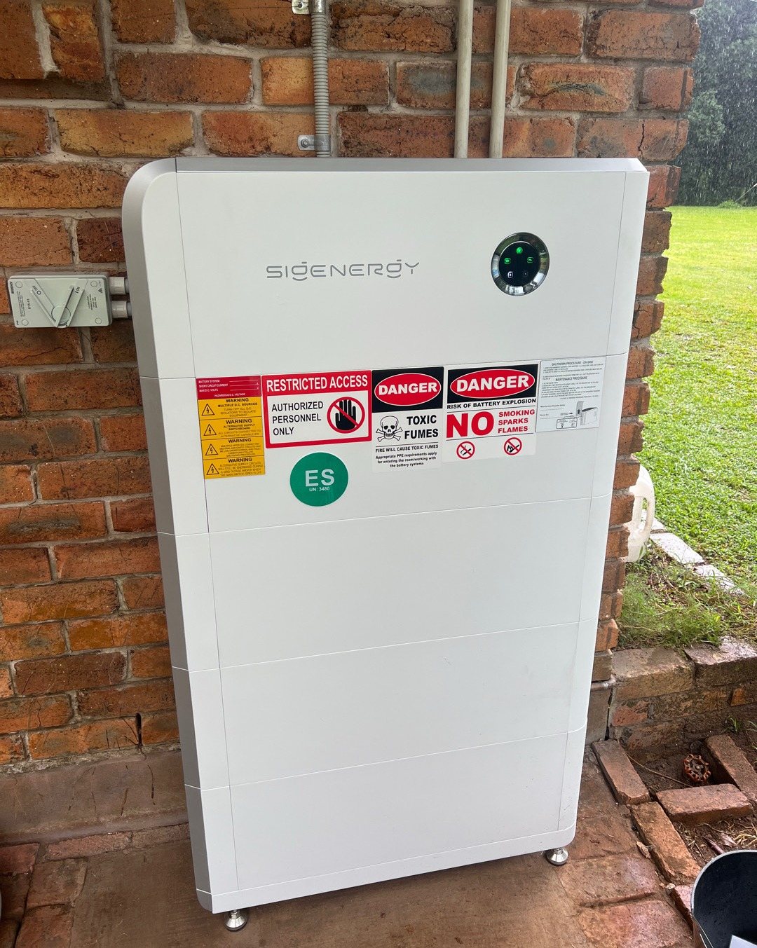 Sigenergy SigenStor 32 kWh battery against an old red brick wall beside the garden at Federal Sigenergy SigenStor 32 kWh battery against an old red brick wall beside the garden at Federal, installed by Sun Connect Solar