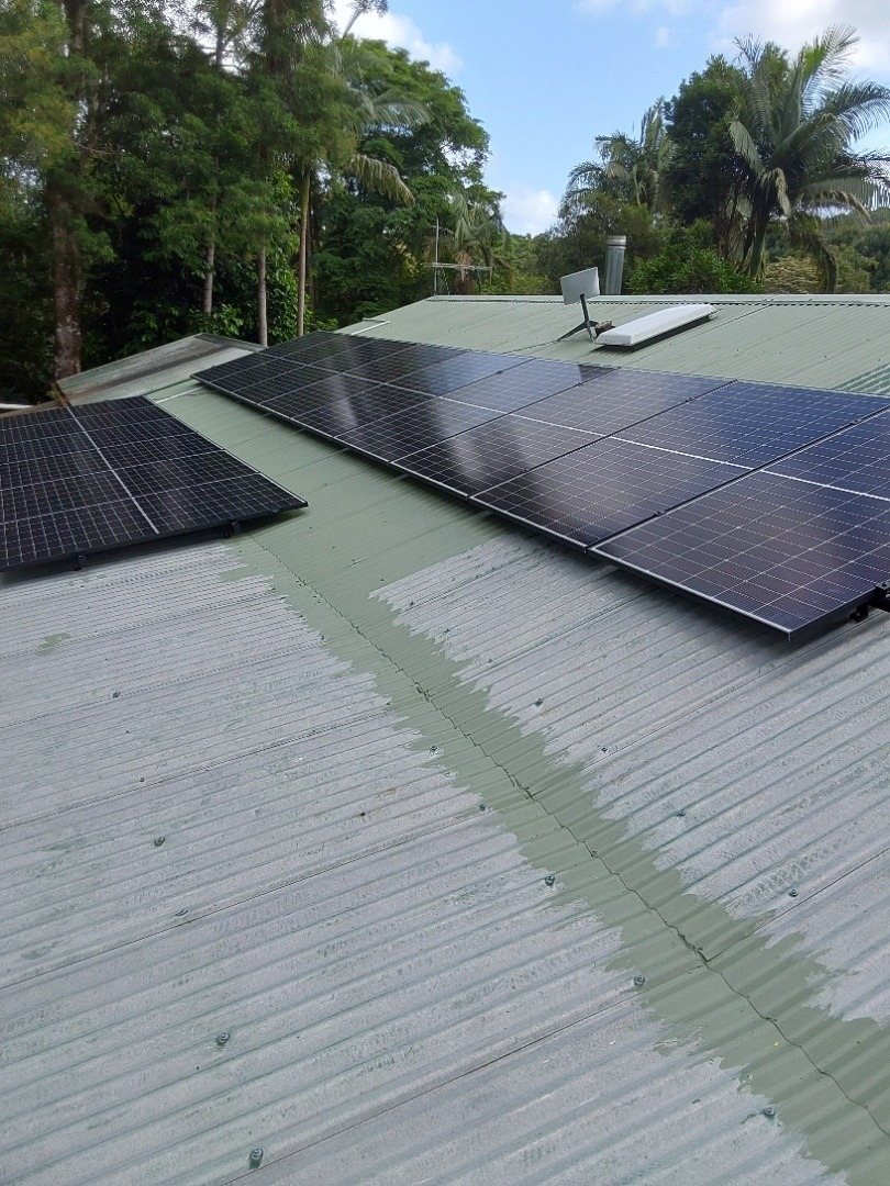A Trina solar array on two faces of a green corrugated roof among palms at Federal A Trina solar array on two faces of a green corrugated roof among palms at Federal, installed by Sun Connect Solar