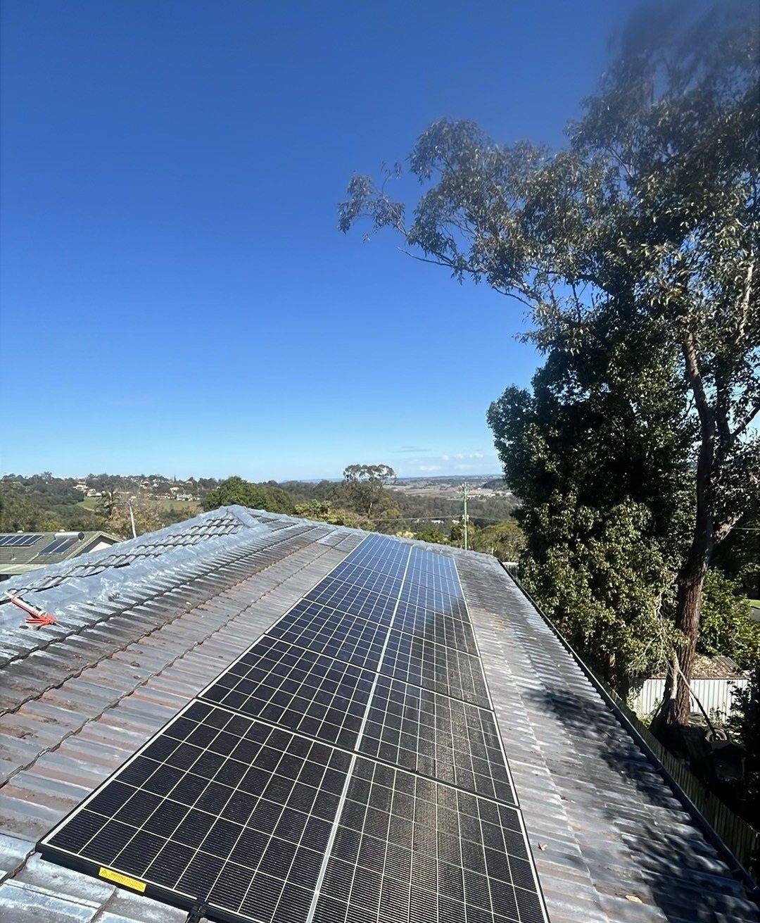 Trina Vertex S+ solar panels in two long rows on a tiled roof in Goonellabah with a gum tree and views to the west Trina Vertex S+ solar panels in two long rows on a tiled roof in Goonellabah with a gum tree and views to the west, part of a 9.5 kW upgrade by Sun Connect Solar