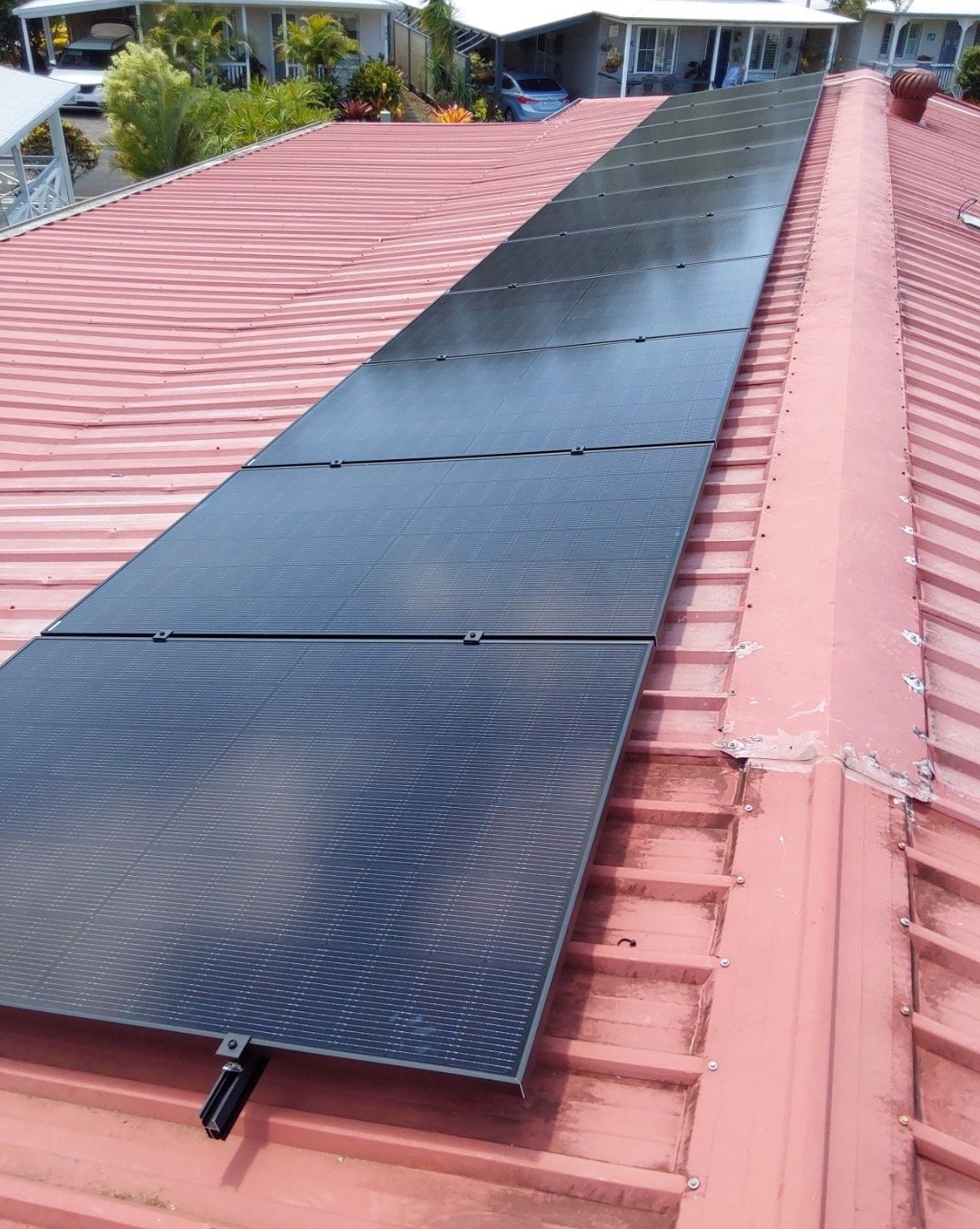 Black Jinko Tiger Neo solar panels in a long run on a red corrugated roof at Hastings Point on the Tweed Coast Black Jinko Tiger Neo solar panels in a long run on a red corrugated roof at Hastings Point on the Tweed Coast, part of a 7.48 kW install by Sun Connect Solar