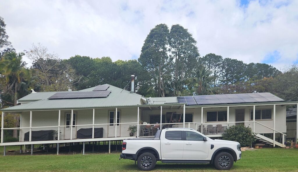 Jinko solar panels on two sections of a green metal roof on a Lismore area home, installed by Sun Connect Solar