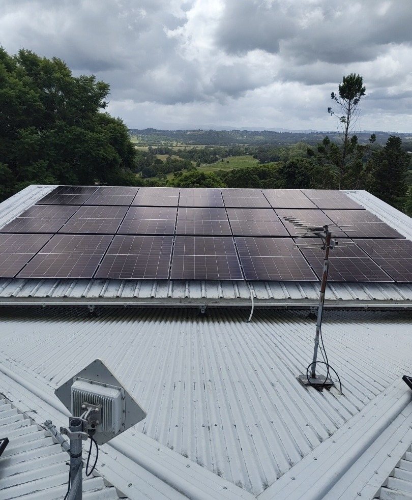 AIKO Neostar solar panels on a corrugated roof with farmland views in the hinterland between Lismore and Bangalow, part of a 19.475 kW install by Sun Connect Solar