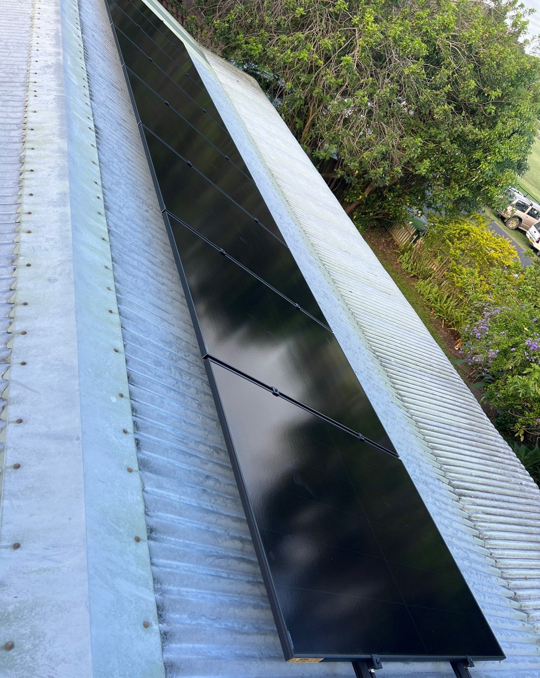 All-black AIKO solar panels along a roof ridge above a leafy garden in Mullumbimby All-black AIKO solar panels along a roof ridge above a leafy garden in Mullumbimby, installed by Sun Connect Solar