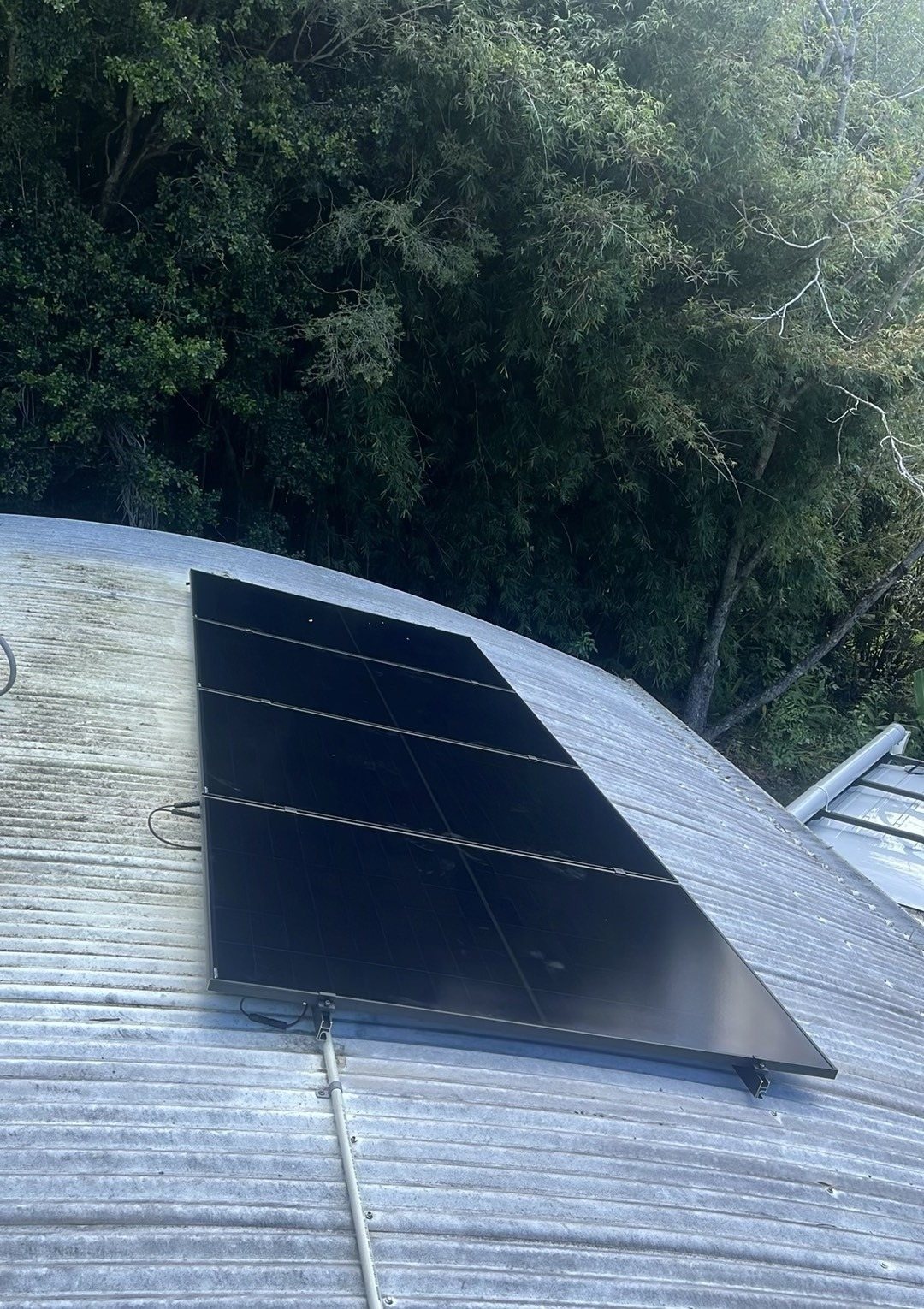 AIKO solar panels on a corrugated roof beside rainforest at Mullumbimby Creek AIKO solar panels on a corrugated roof beside rainforest at Mullumbimby Creek, part of an 8.37 kW solar and Sigenergy battery install by Sun Connect Solar