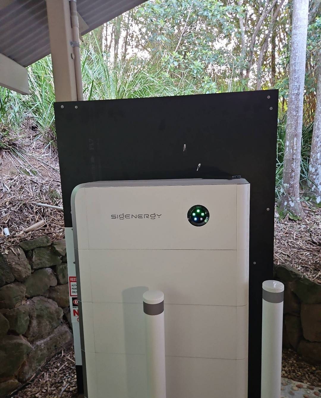 Sigenergy SigenStor 27 kWh battery raised on blocks with a backing board and two bollards at Mullumbimby Creek Sigenergy SigenStor 27 kWh battery raised on blocks with a backing board and two bollards at Mullumbimby Creek, installed by Sun Connect Solar