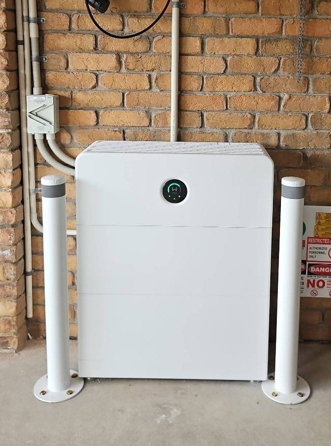 GoodWe ESA all-in-one battery GoodWe ESA all-in-one battery, about 16.6 kWh, between two protective bollards against a brick wall in Mullumbimby, installed by Sun Connect Solar