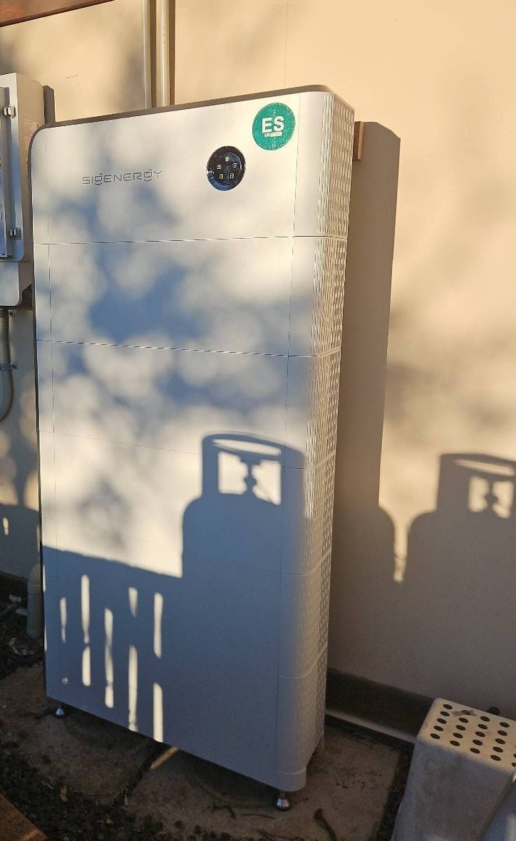 Tall Sigenergy SigenStor three-phase battery stack, about 50 kWh, against a rendered wall in the Mullumbimby hinterland, installed by Sun Connect Solar