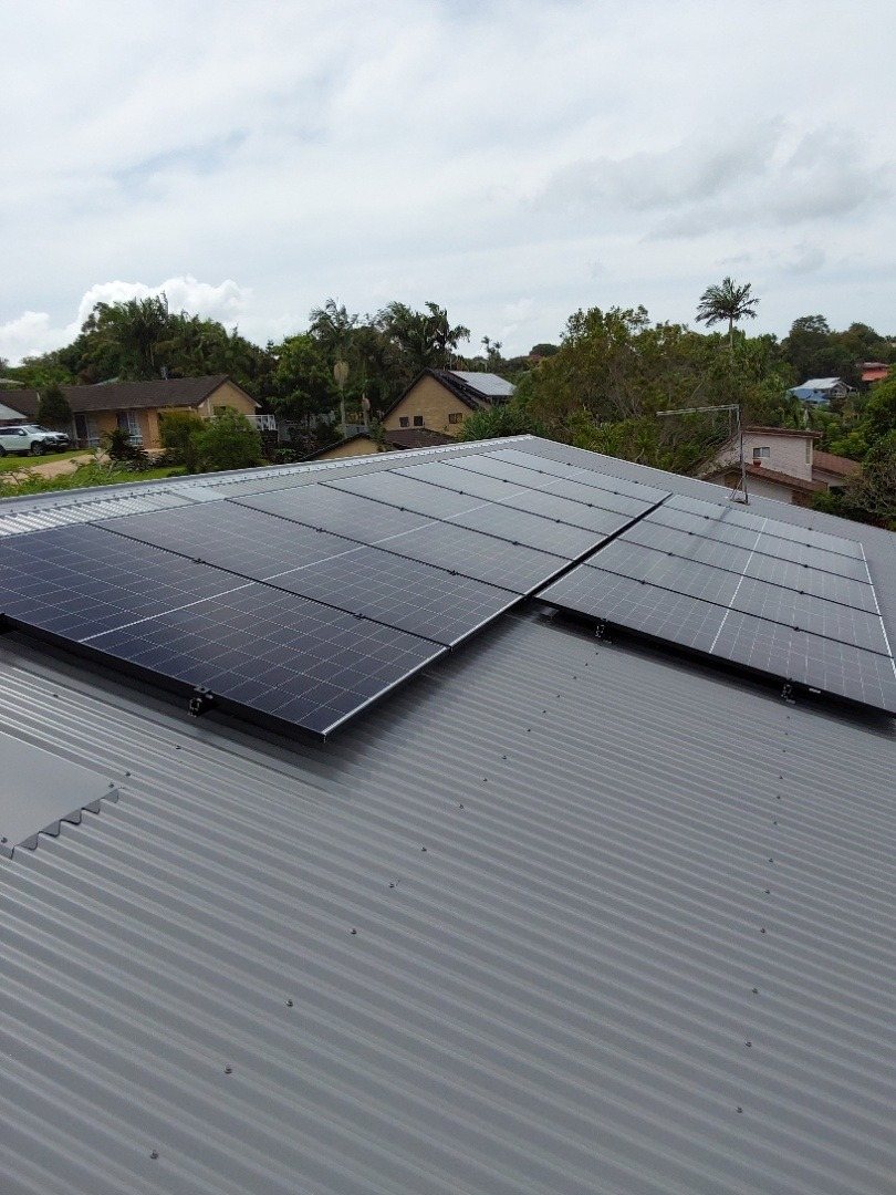 Jinko Tiger Neo solar panels on two faces of a grey Colorbond roof looking over Ocean Shores, part of a 10.45 kW install by Sun Connect Solar