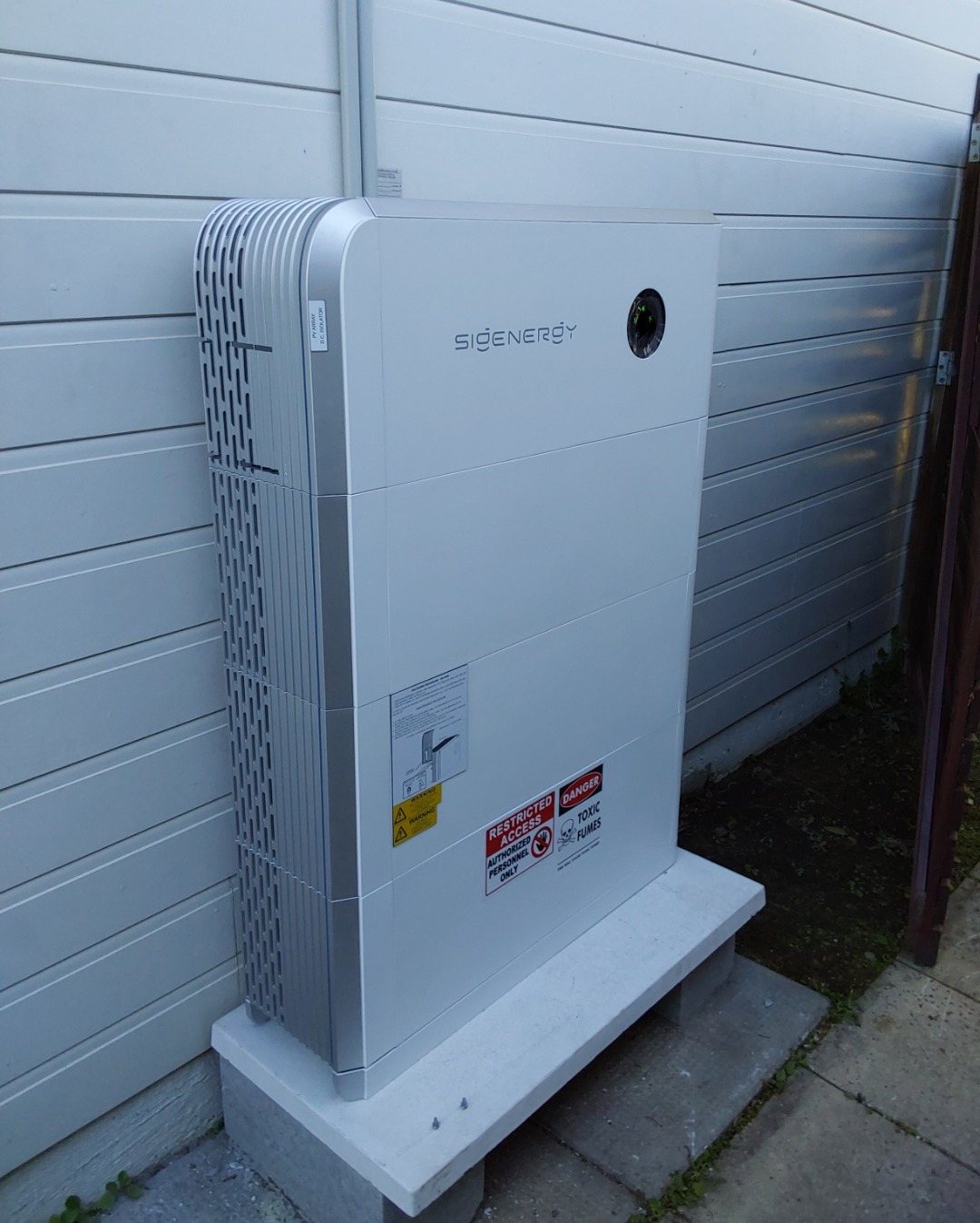 Sigenergy SigenStor 24 kWh battery on a concrete base beside a weatherboard wall in Ocean Shores, installed by Sun Connect Solar