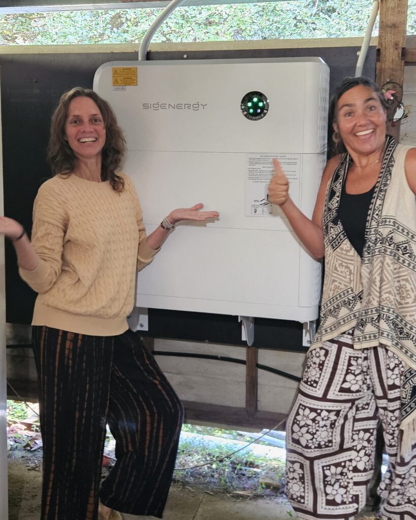 Two Wilsons Creek customers beside their new wall-mounted Sigenergy battery, installed by Sun Connect Solar