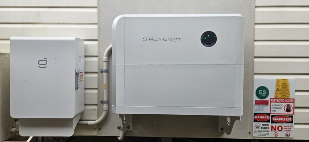 Sigenergy SigenStor home battery mounted on an outside wall with warning signage, Lismore area install by Sun Connect Solar