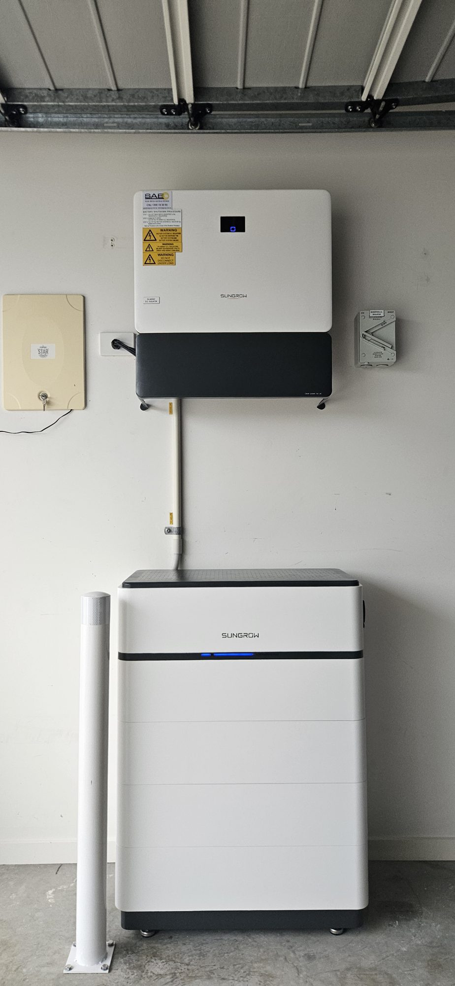 Sungrow hybrid inverter mounted above a Sungrow battery stack in a garage, installed by Sun Connect Solar