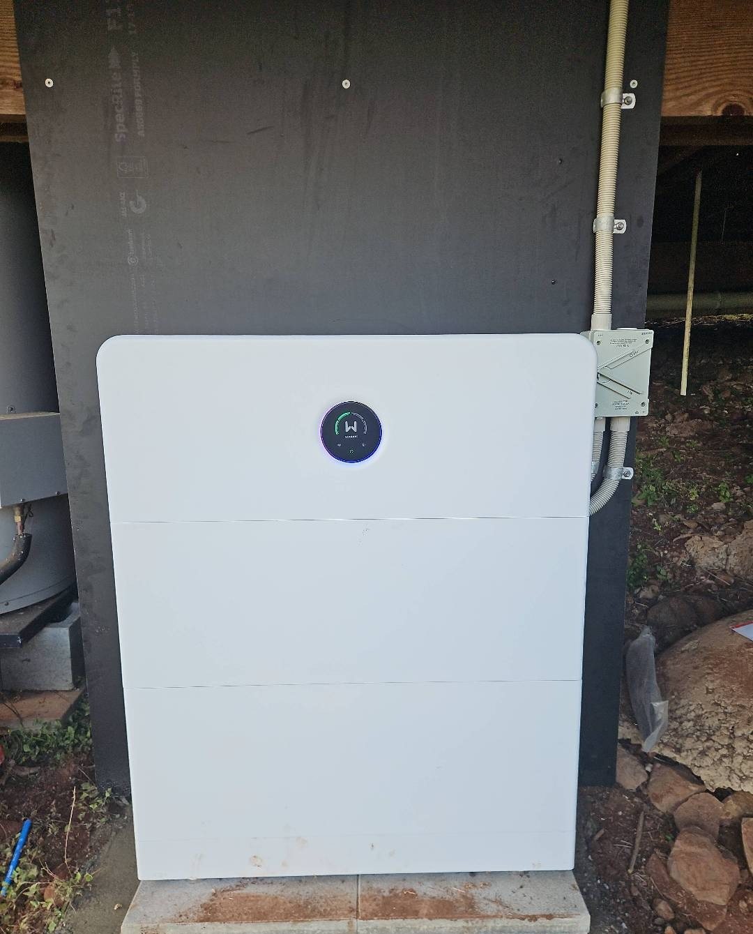 GoodWe ESA all-in-one battery with two battery modules on a backing board under a raised house at The Channon GoodWe ESA all-in-one battery with two battery modules on a backing board under a raised house at The Channon, installed by Sun Connect Solar